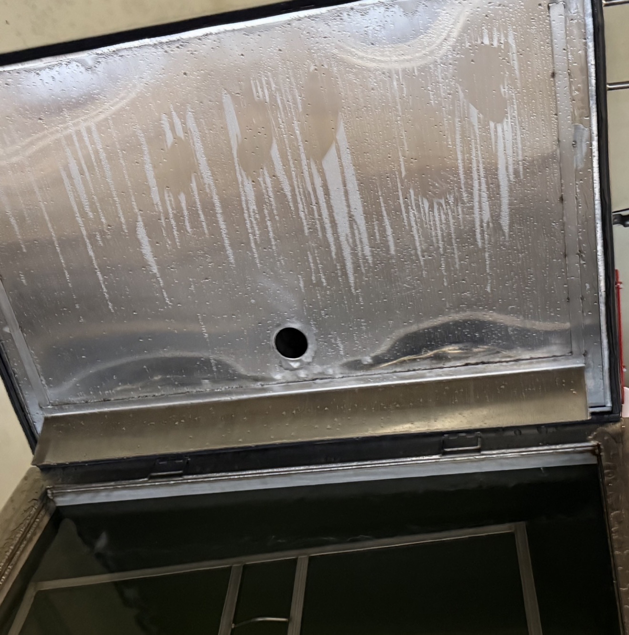 Open WL4 tank lid showing condensate on the underside and the stainless drip guard returning liquid to the tank